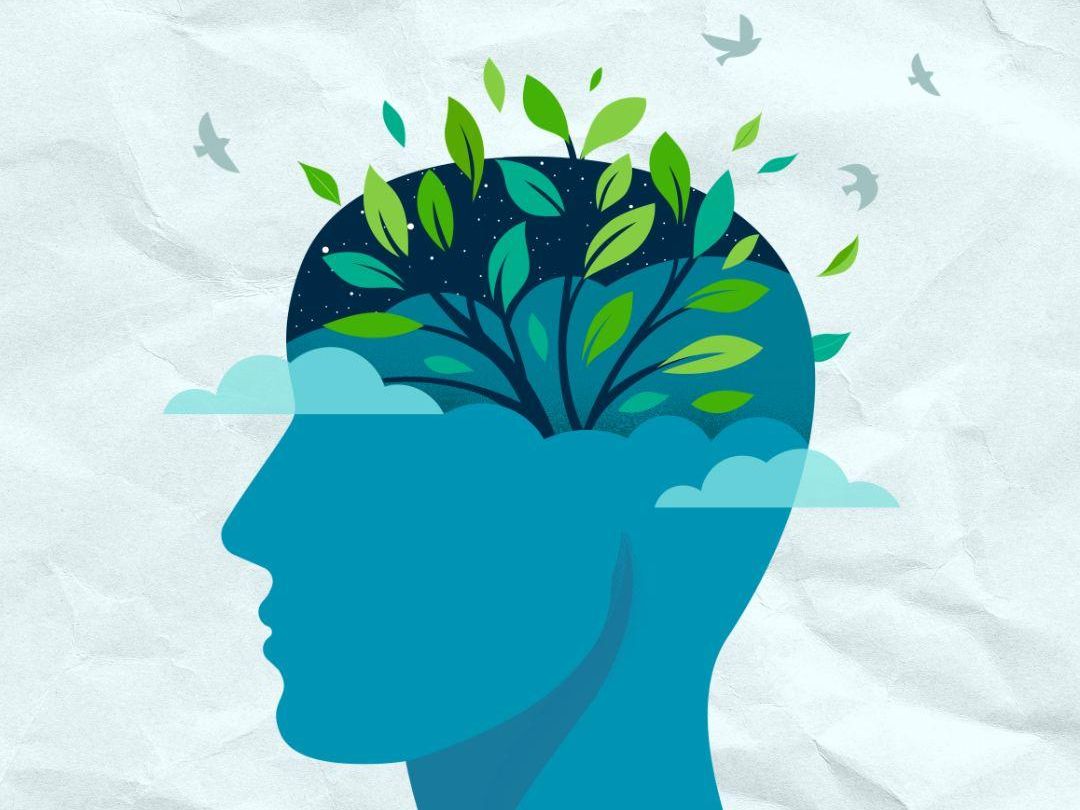 graphic of vibrant green leaves and birds in the brain area representing mental health awareness month