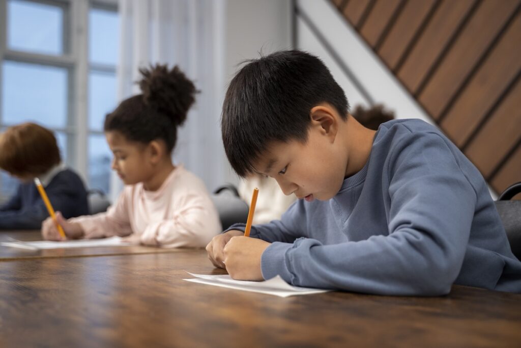 close-up of two K-12 students working on their assignments at their desk